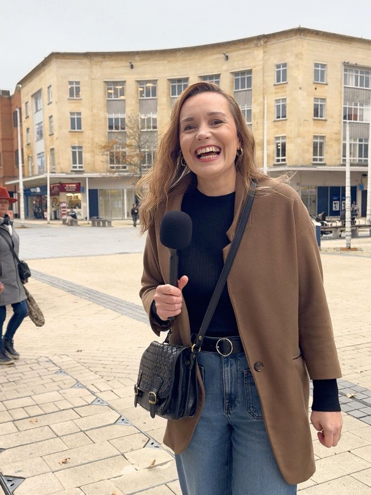 Gosia Scarrott holding a microphone on a UK high street